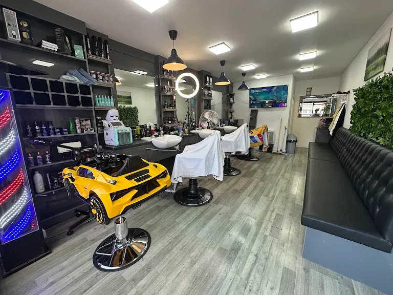 The shop floor with barber chairs, a yellow car chair for children and a leather bench